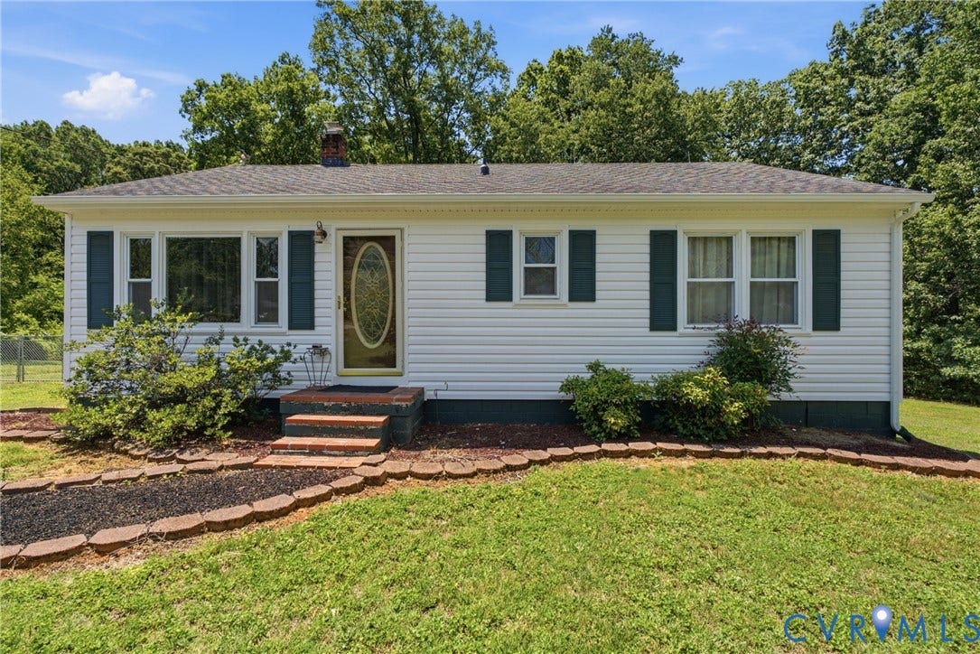 303 W 8th Street, Town Of Mineral, Mineral, VA 23117 White siding exterior with dark shutters, featuring a front door with an oval-shaped decorative glass insert