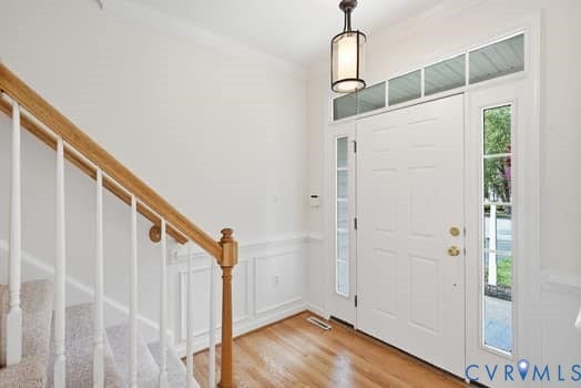 5213 Wheat Ridge Place, Chappell Ridge, Glen Allen, VA 23059 Foyer featuring a paneled entry door with sidelights and transom window, a bronze-finish pendant light fixture, wood-finish flooring, wainscoting, and a staircase with a wood handrail