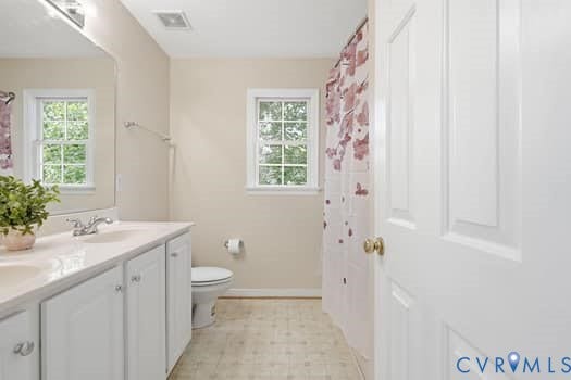 5213 Wheat Ridge Place, Chappell Ridge, Glen Allen, VA 23059 Bathroom featuring a white vanity with dual sinks, a large wall mirror, and a window with grid panes