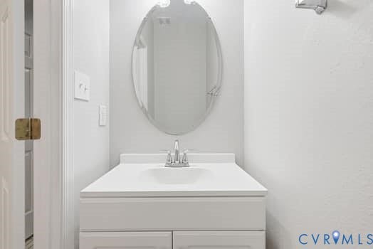 5213 Wheat Ridge Place, Chappell Ridge, Glen Allen, VA 23059 Bathroom vanity featuring a white countertop, oval mirror, and chrome faucet