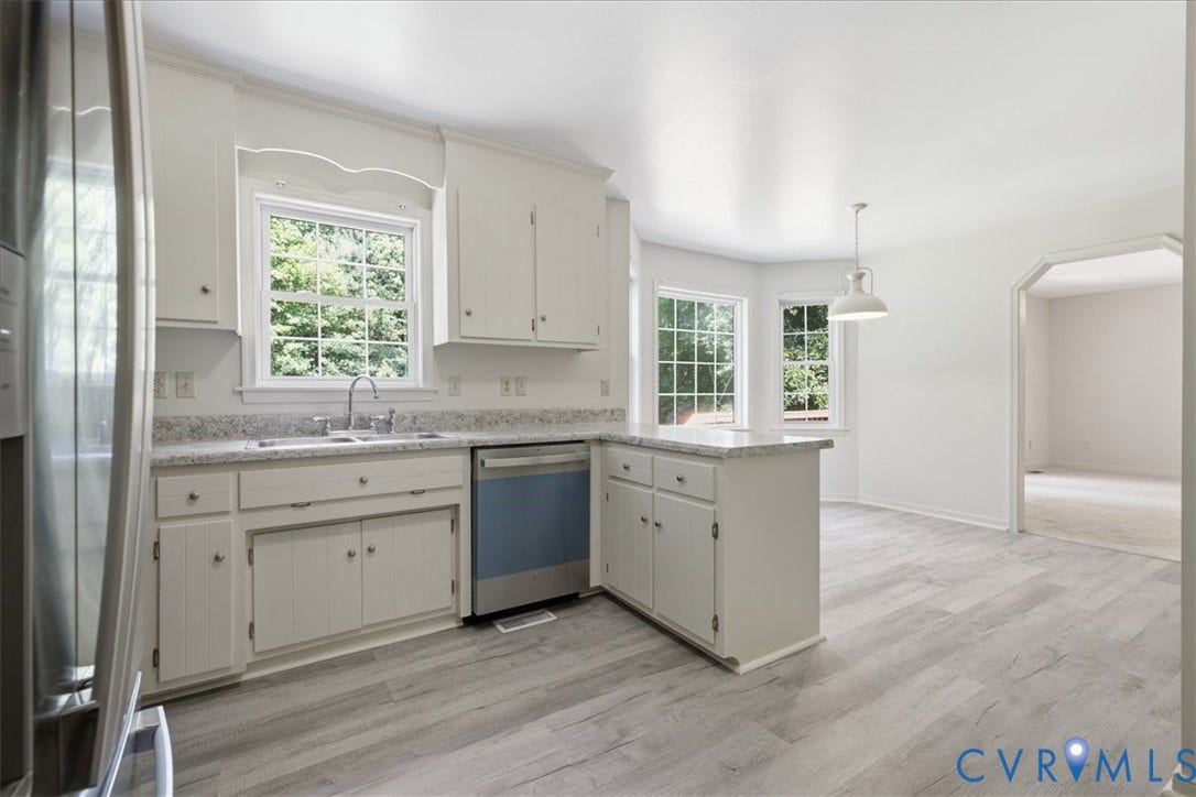 L-shaped kitchen featuring freshly painted cabinetry, a stainless steel sink, and new stainless steel dishwasher