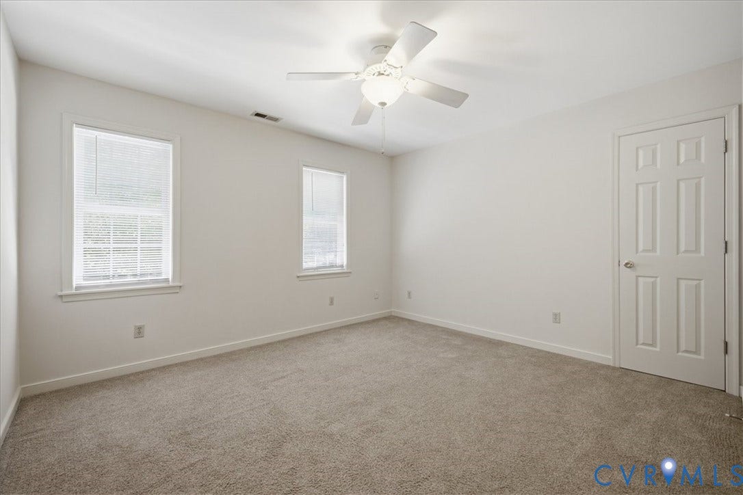 Carpeted bedroom #3 featuring two windows facing the front of the house.