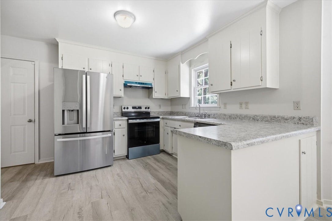 Kitchen featuring new LVP flooring, white cabinetry, speckled countertops, and new stainless steel appliances