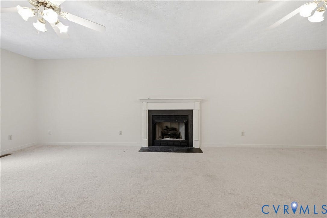 Spacious Family room featuring a gas fireplace , and two ceiling fans with integrated lighting