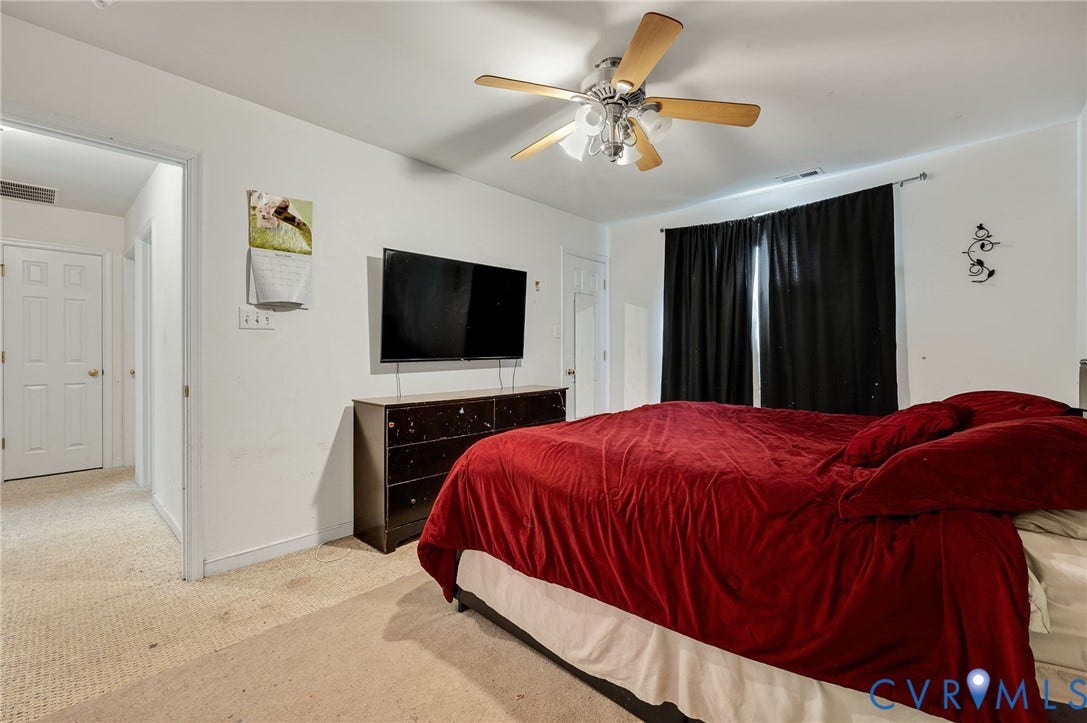 1207 Wycliff Court, Richmond, VA 23236 Carpeted room featuring a ceiling fan with light fixture, a window with dark curtains, and a doorway