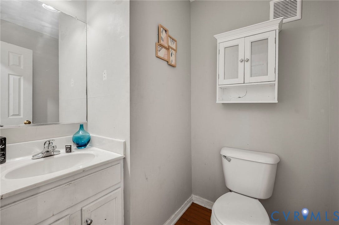 1207 Wycliff Court, Richmond, VA 23236 Bathroom featuring a vanity with an integrated sink, polished chrome faucet, wall-mounted mirror, and white cabinetry