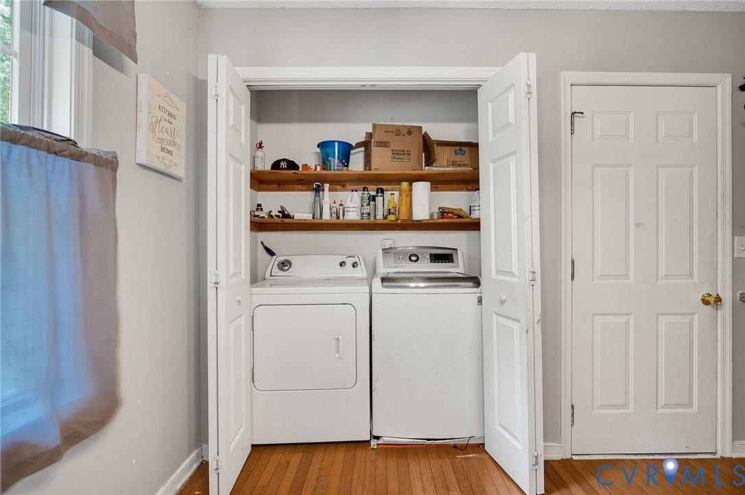 1207 Wycliff Court, Richmond, VA 23236 Dedicated laundry closet featuring a stacked washer and dryer, wood-finish flooring, bi-fold doors, and integrated shelving