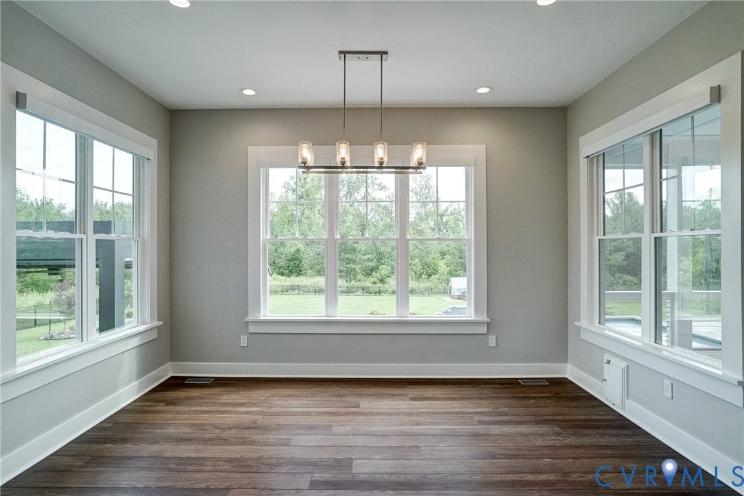 1732 Fishers Pond Drive, Maidens, VA 23102 Spacious room featuring rich wood-finish flooring, recessed lighting, and a modern linear chandelier