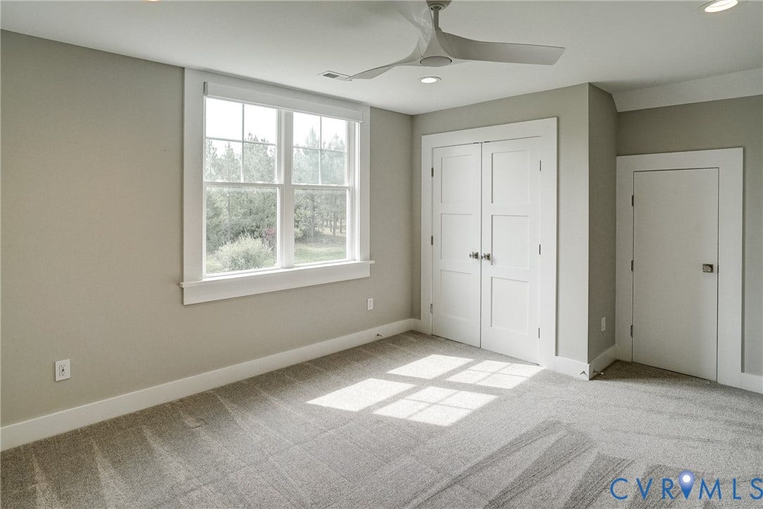 1732 Fishers Pond Drive, Maidens, VA 23102 Bright room featuring a multi-pane window, flush-panel doors, a modern ceiling fan, recessed lighting, and grey carpet flooring