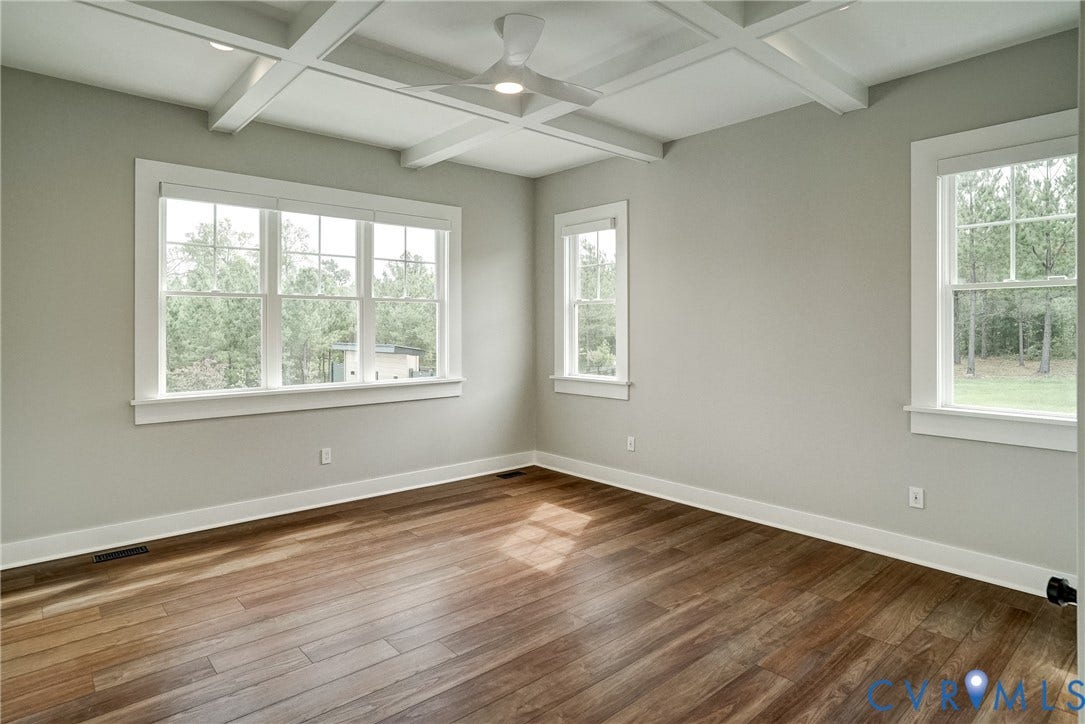 1732 Fishers Pond Drive, Maidens, VA 23102 Spacious room featuring coffered ceilings, expansive windows, wood-finish flooring, and light-toned wall paint