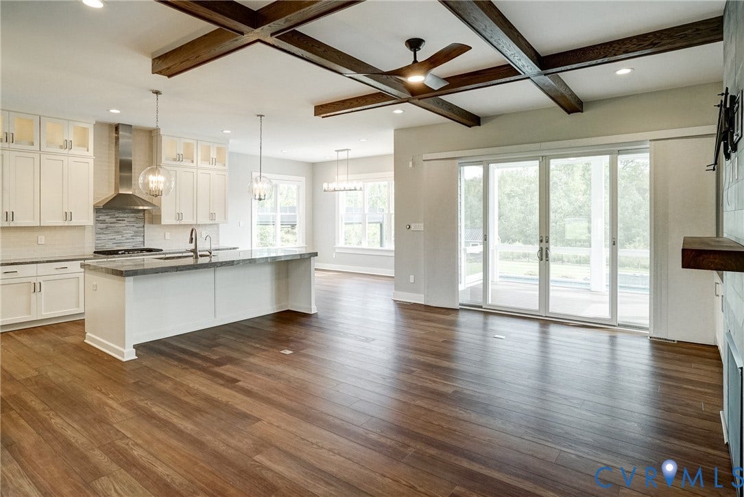1732 Fishers Pond Drive, Maidens, VA 23102 Expansive open-concept living area featuring wood-finish flooring and a coffered ceiling with exposed beams