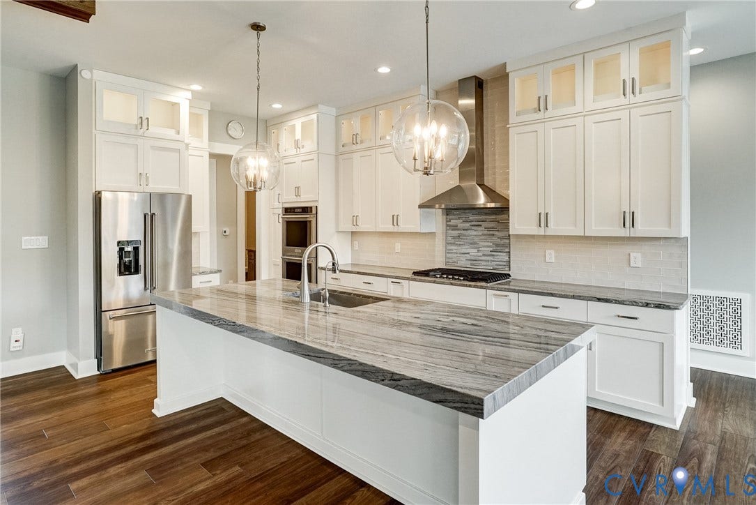 1732 Fishers Pond Drive, Maidens, VA 23102 Gourmet kitchen featuring a large central island with a stone countertop, white cabinetry with display uppers, stainless steel appliances, and wood-finish flooring