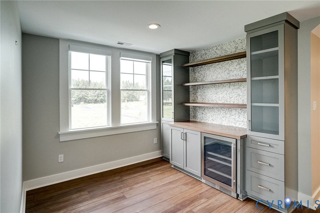 1732 Fishers Pond Drive, Maidens, VA 23102 Built-in cabinetry with glass-front uppers, wood-finish shelving, and integrated beverage cooler