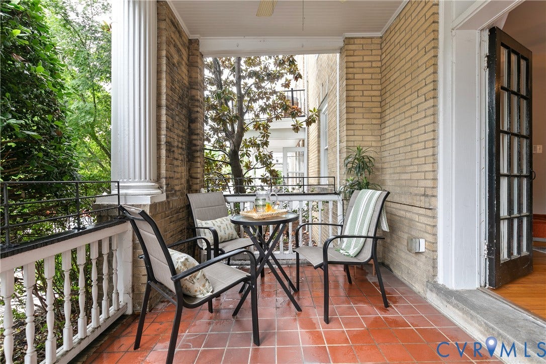 601 Roseneath Road, #U1, Museum District, Richmond, VA 23221 Patio featuring terra cotta tile flooring, light brick wall, white balusters, black metal railing, and a column with fluted details