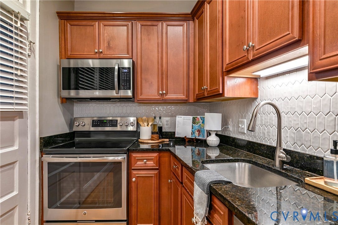 601 Roseneath Road, #U1, Museum District, Richmond, VA 23221 Kitchen featuring wood-finish cabinetry, dark stone countertops, and a full stainless steel appliance suite