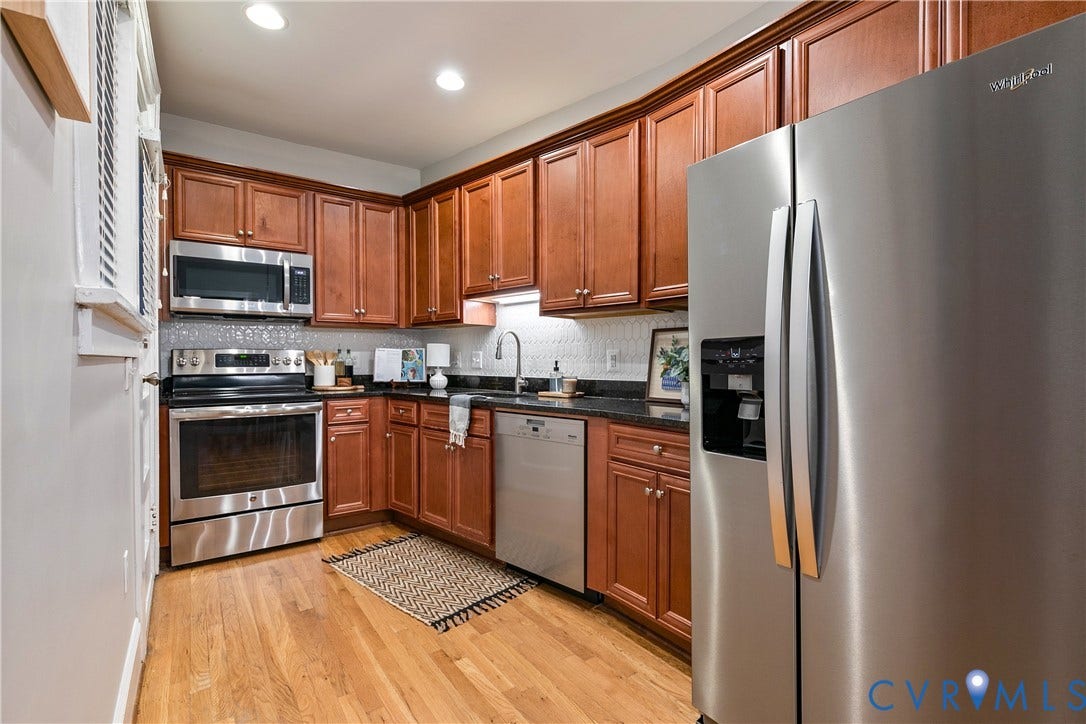 601 Roseneath Road, #U1, Museum District, Richmond, VA 23221 Contemporary kitchen featuring wood-finish cabinetry, dark countertops, stainless steel appliances, and a tiled backsplash