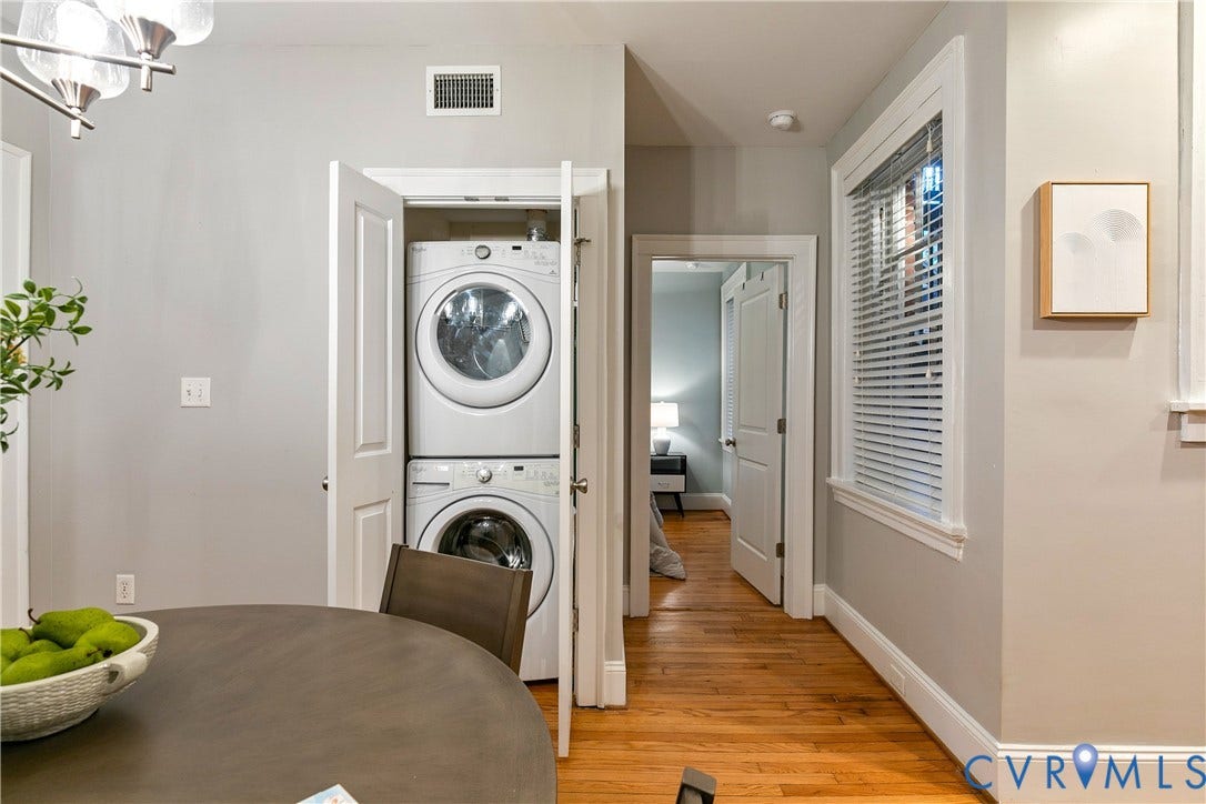 601 Roseneath Road, #U1, Museum District, Richmond, VA 23221 Integrated laundry closet featuring a stacked washer and dryer, wood-finish flooring, white trim, and a window with horizontal blinds
