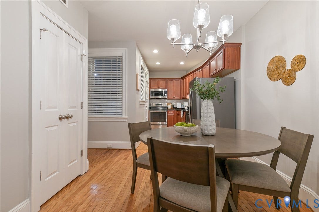 601 Roseneath Road, #U1, Museum District, Richmond, VA 23221 Dining area featuring wood-finish flooring, a modern chandelier, and access to a kitchen with cherry wood cabinetry and stainless steel appliances