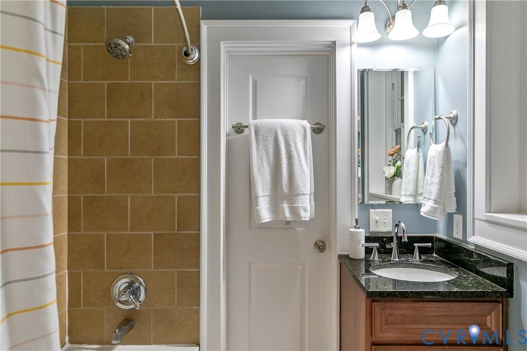 601 Roseneath Road, #U1, Museum District, Richmond, VA 23221 Bathroom featuring a wood vanity with a granite countertop and undermount sink, mirrored medicine cabinet, and a tiled shower surround with a chrome showerhead