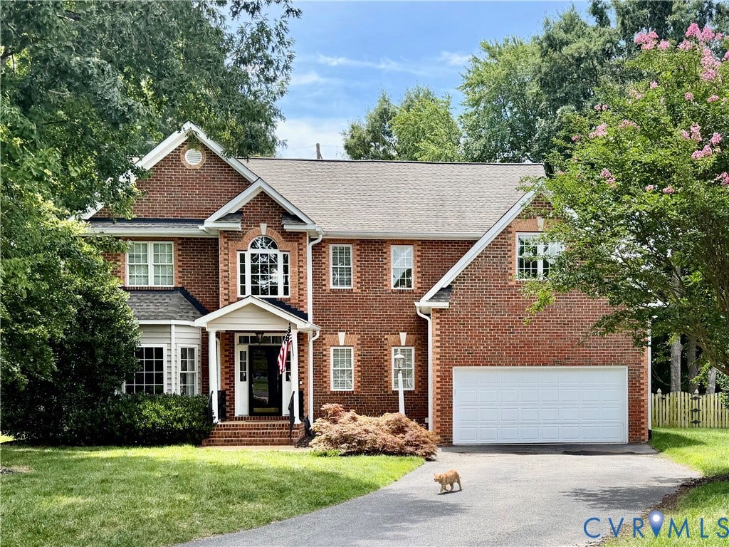 5102 Park Meadows Court, Henrico, VA 23059 Traditional brick exterior featuring white trim accents, a prominent front porch, a two-car garage, multiple windows, and a mature tree canopy
