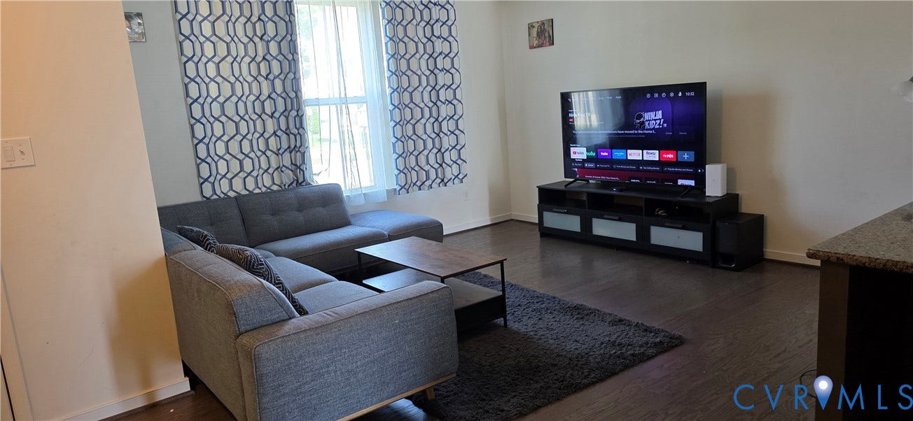 Living area featuring wood-finish flooring and light-toned walls