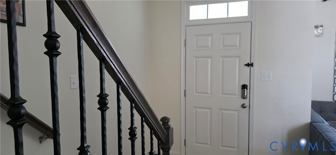 White paneled entry door with transom window
