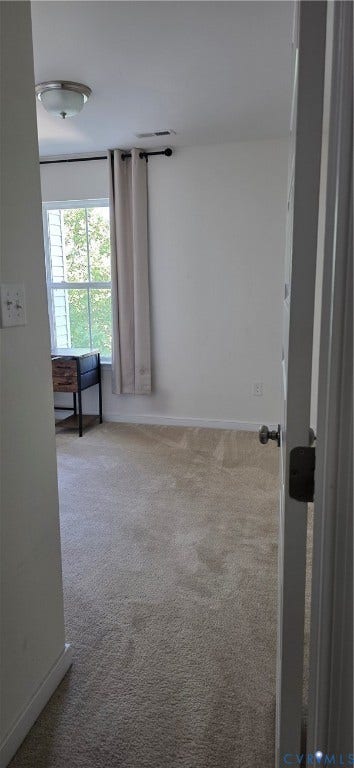 Carpeted interior space with a window offering natural light