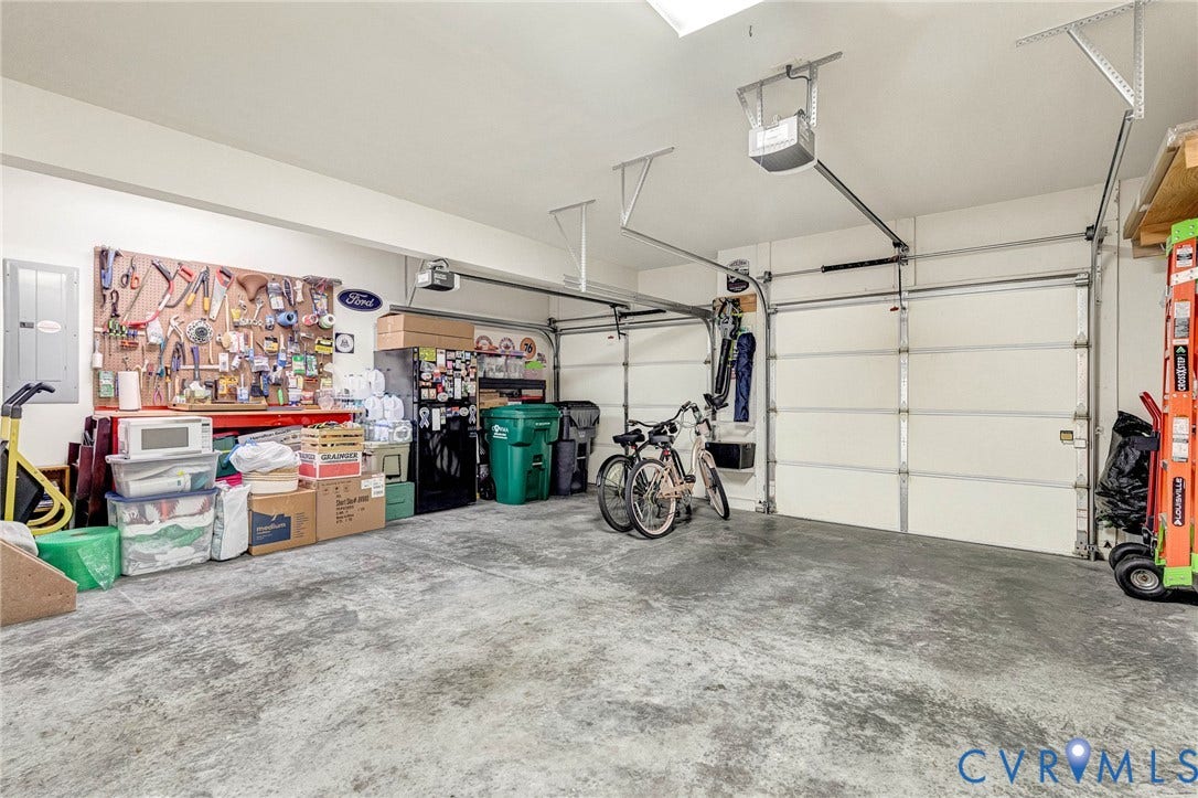 1020 Belva Court, Glen Allen, VA 23059 Two-car garage featuring a concrete floor, white panel garage doors, and an overhead lighting fixture