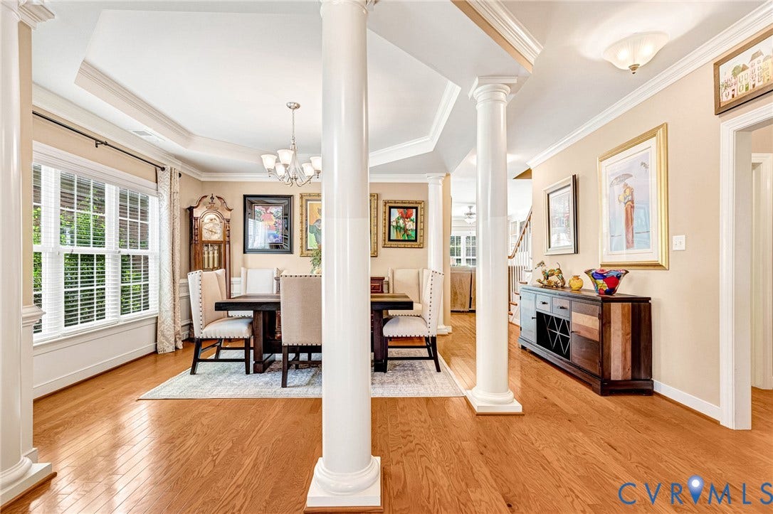 1020 Belva Court, Glen Allen, VA 23059 Formal dining area featuring hardwood flooring, architectural columns, tray ceiling, and a chandelier