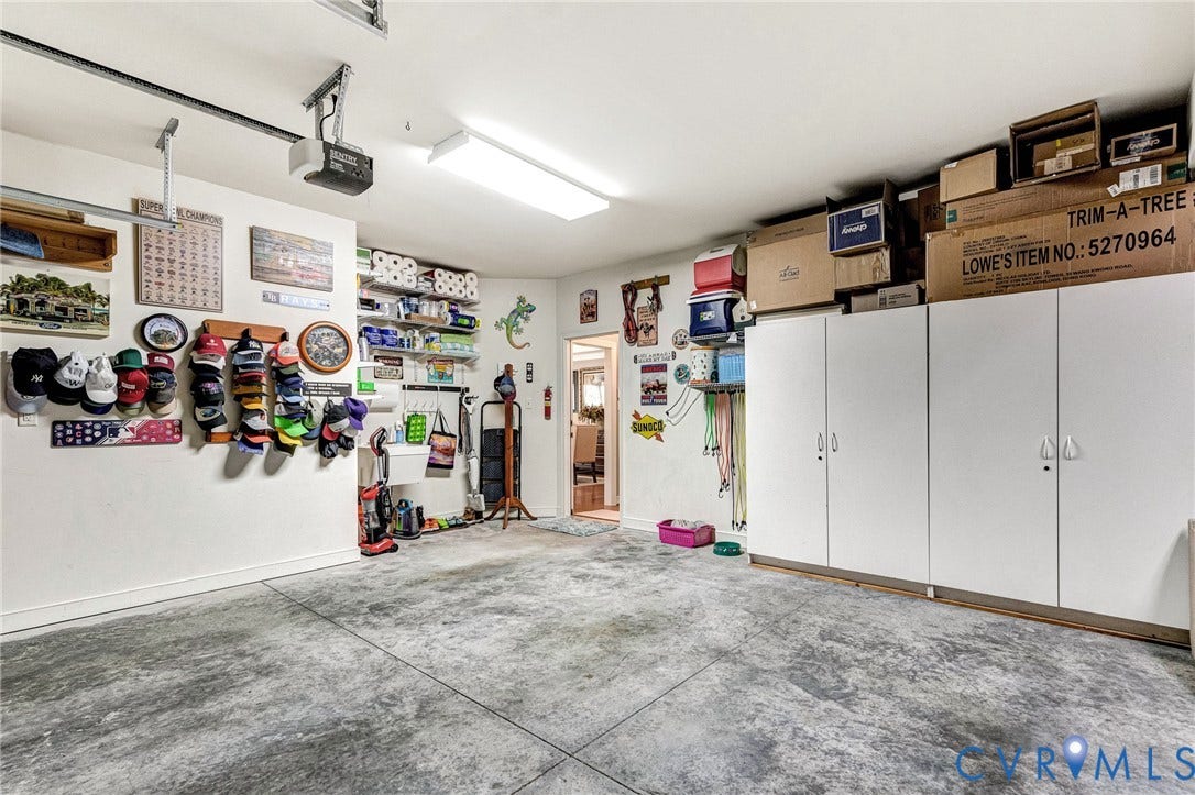 1020 Belva Court, Glen Allen, VA 23059 Spacious garage featuring a concrete floor, overhead lighting, garage door opener, and extensive built-in white cabinetry for storage