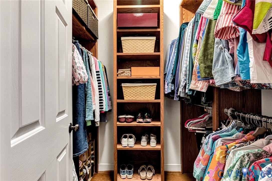 1020 Belva Court, Glen Allen, VA 23059 Built-in closet system featuring natural wood shelving, multiple hanging rods, and integrated storage compartments