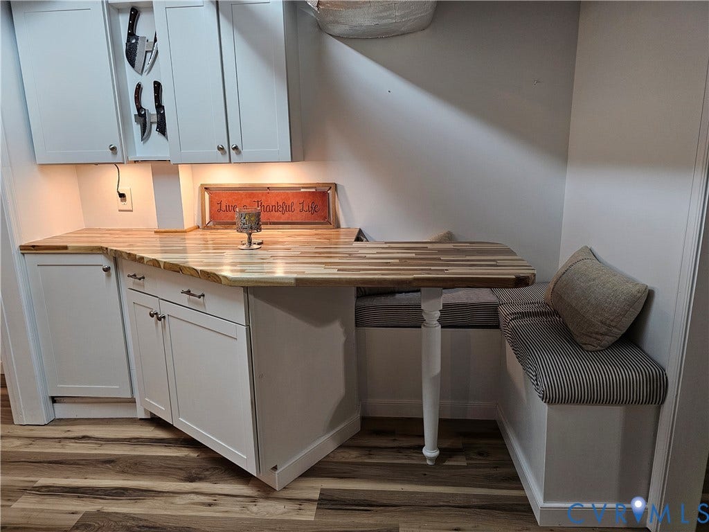 14600 Ramblewood Drive, Chester, VA 23836 Built-in banquette seating with under-cabinet lighting, wood-finish flooring, white cabinetry, and a butcher block countertop