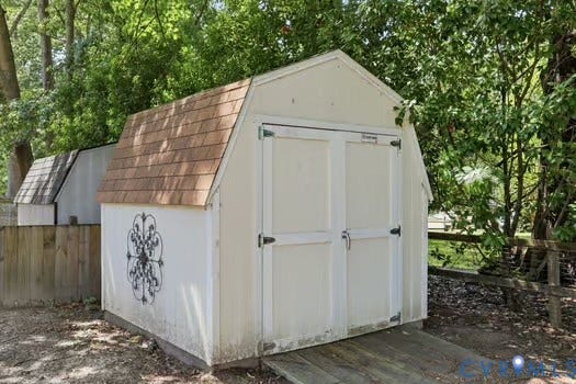 2804 Executive Drive, John Tyler Woods, Chester, VA 23831 Freestanding storage shed featuring a gambrel roof with asphalt shingles, double doors, and a decorative metal accent