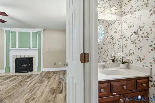 2804 Executive Drive, John Tyler Woods, Chester, VA 23831 Powder room featuring a wood-finish vanity with an integrated sink, an octagonal window, and sconce lighting