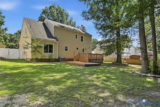 2804 Executive Drive, John Tyler Woods, Chester, VA 23831 Expansive backyard featuring a multi-level wood deck, a white privacy fence, and mature trees