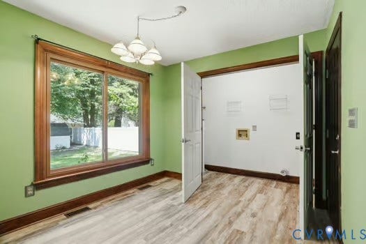 2804 Executive Drive, John Tyler Woods, Chester, VA 23831 Eating area and laundry featuring LVP flooring, a large window with wood trim, and a five-light ceiling fixture