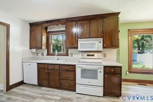 2804 Executive Drive, John Tyler Woods, Chester, VA 23831 Kitchen featuring wood-finish cabinetry, white countertops, a white tile backsplash, and a white appliance suite including a dishwasher, range, and microwave