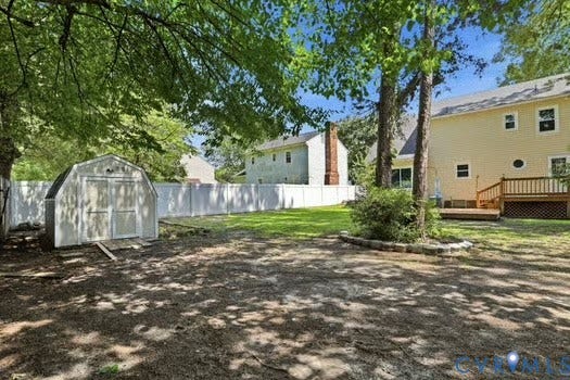 2804 Executive Drive, John Tyler Woods, Chester, VA 23831 Expansive backyard featuring mature trees, a white privacy fence, and a storage shed