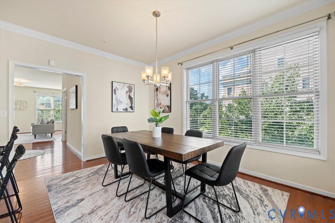 Hardwood-finish flooring, crown molding, and large windows with blinds