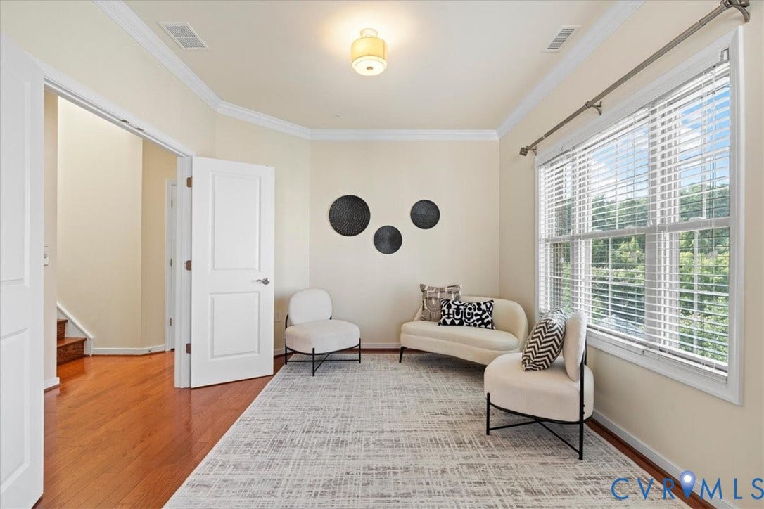 Hardwood flooring, crown molding, double windows with blinds, recessed ceiling light fixture, and white paneled doors