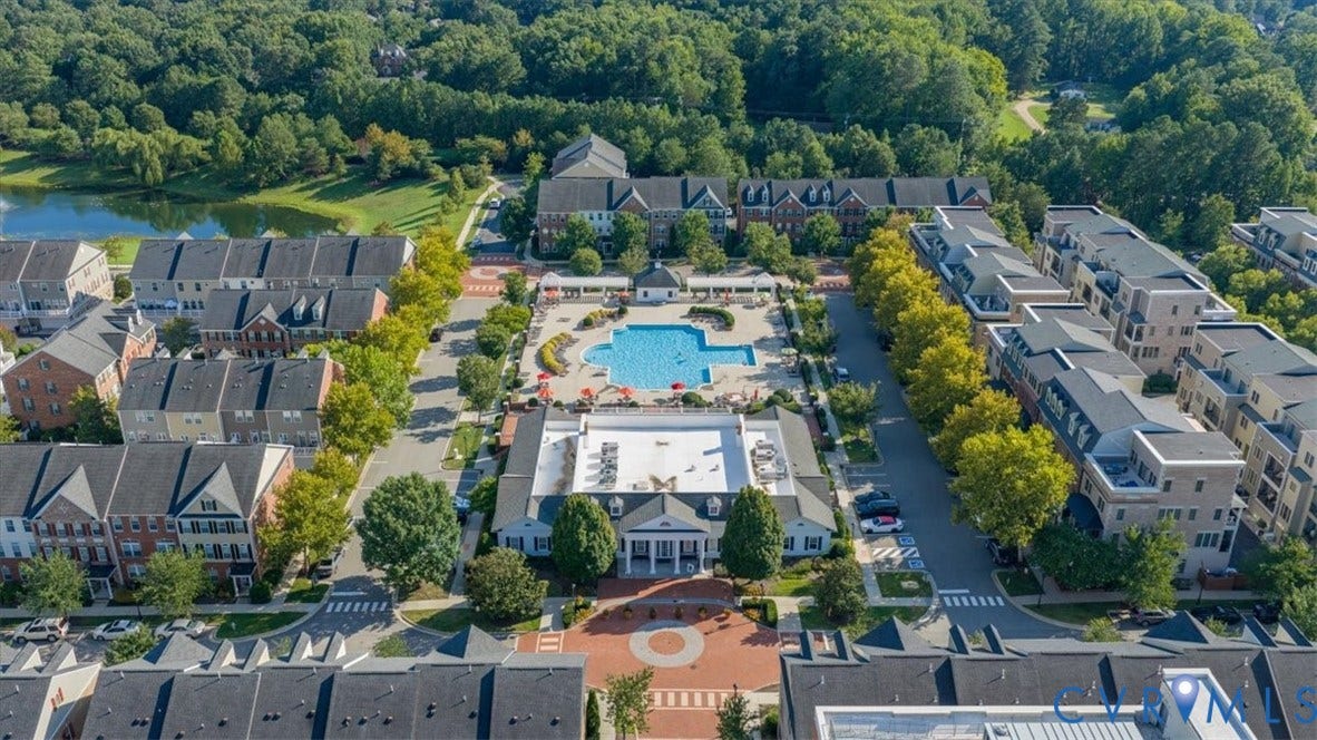 Community Clubhouse with a Olympic size swimming pool, surrounded by multi-story residential buildings, and verdant landscaping