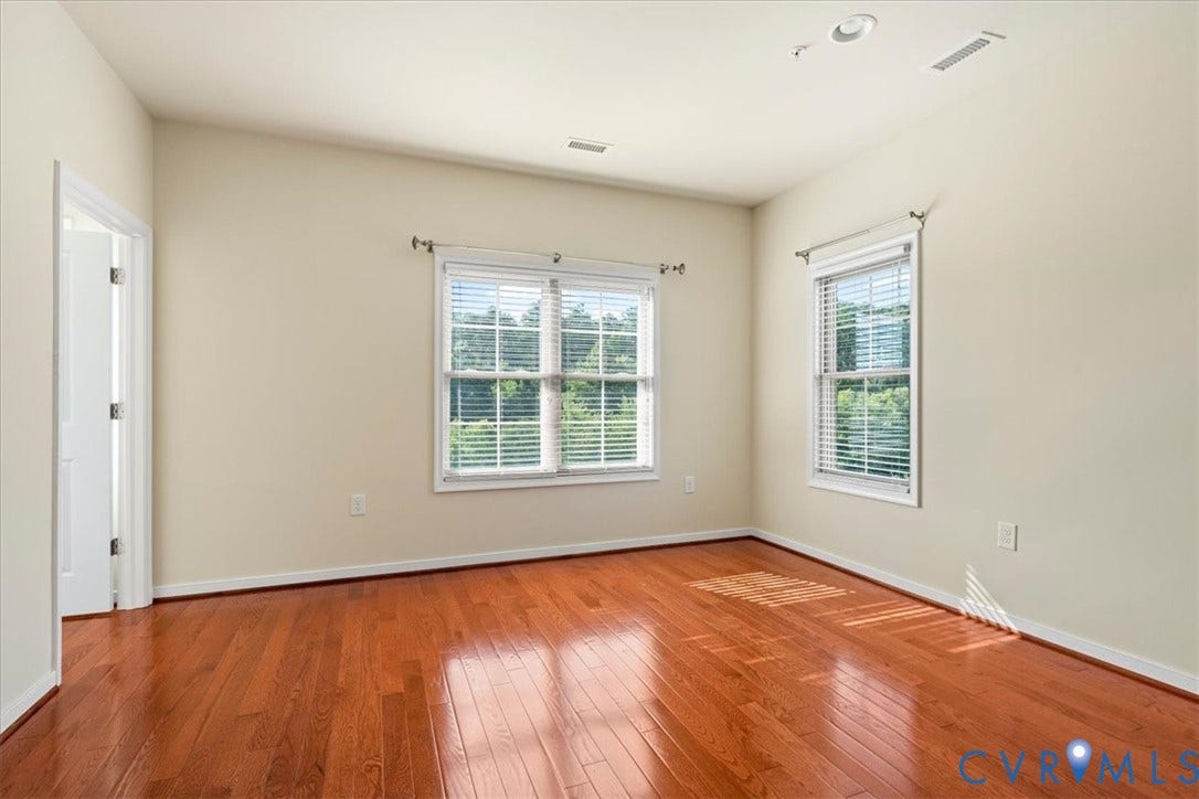 Hardwood flooring, recessed lighting, and dual windows with blinds