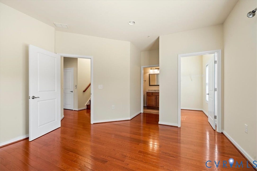 Hardwood flooring, painted interior walls, contemporary white doors, recessed lighting, and a bathroom vanity with a framed mirror