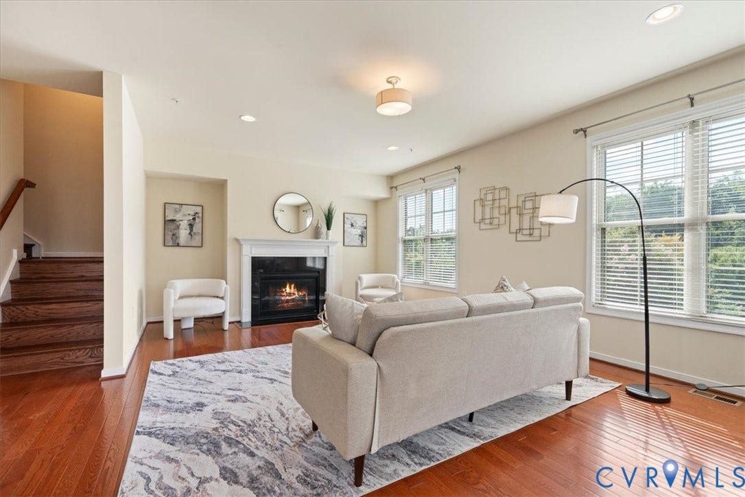 Hardwood flooring, fireplace with mantel, recessed lighting, ceiling-mounted light fixture, and multiple windows