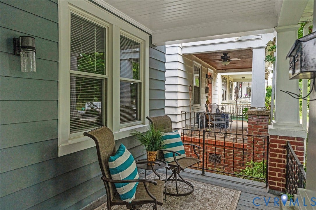 3314 Grayland Avenue, Richmond, VA 23221 Inviting covered porch featuring blue-gray siding, white trim, and a decorative outdoor light fixture