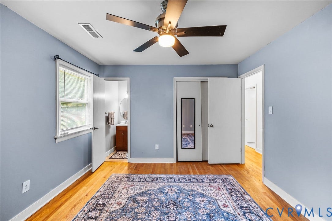 Bedroom featuring wood-finish flooring, light blue painted walls, and a ceiling fan with integrated lighting