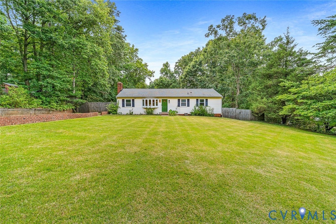 Spacious front yard with expansive lawn and mature tree surroundings