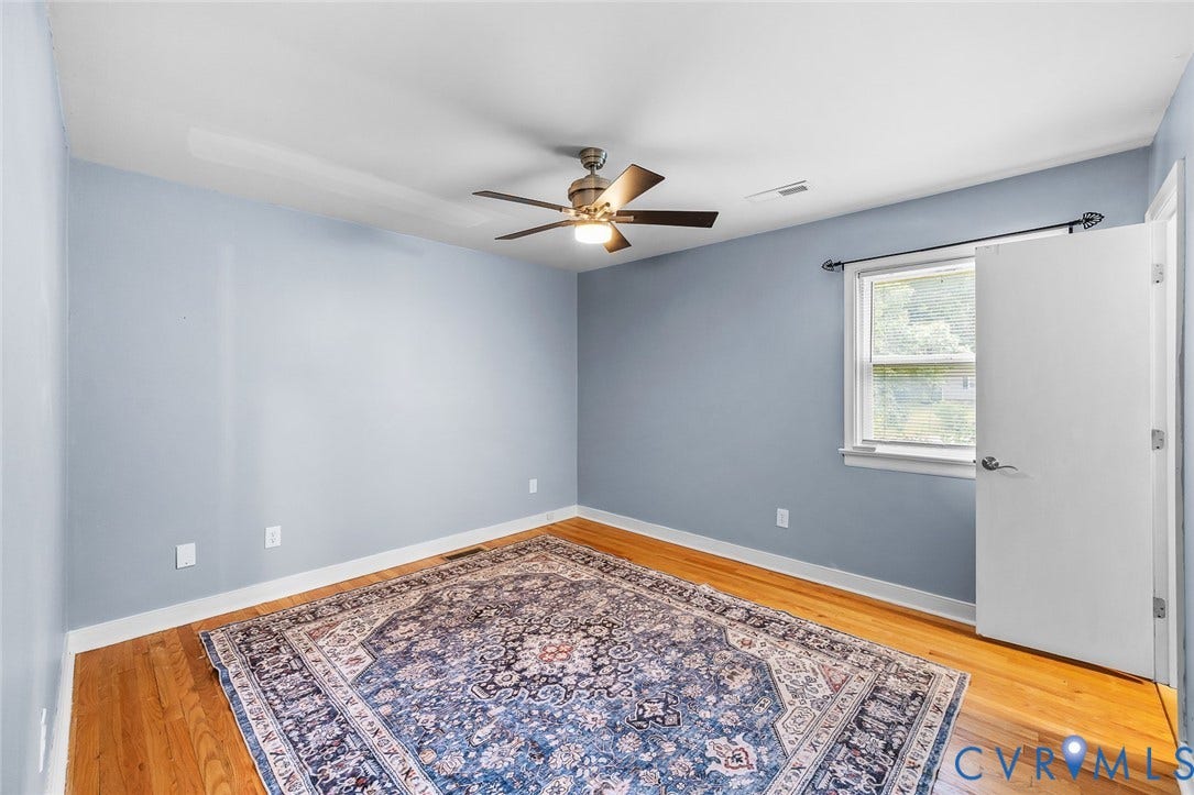 Hardwood flooring throughout, complemented by light blue wall tones and white trim