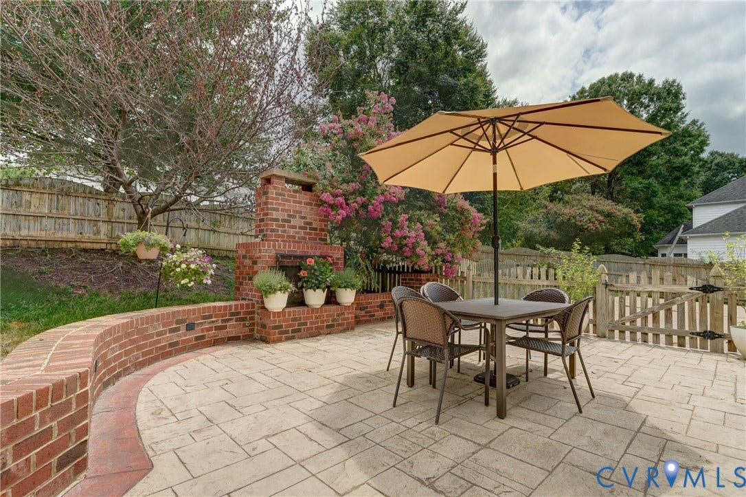 332 Rexmoor Terrace, Richmond, VA 23236 Expansive patio featuring stamped concrete, a substantial brick fireplace, and a curved brick retaining wall