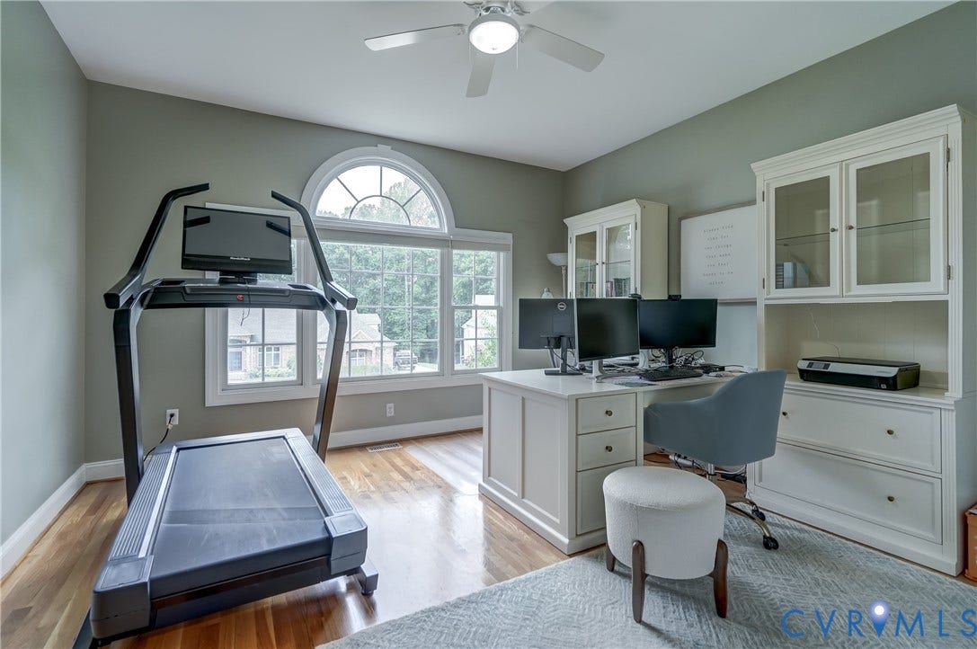332 Rexmoor Terrace, Richmond, VA 23236 Hardwood flooring throughout featuring large windows, an arched transom window, a ceiling fan, and built-in cabinetry with glass-front uppers
